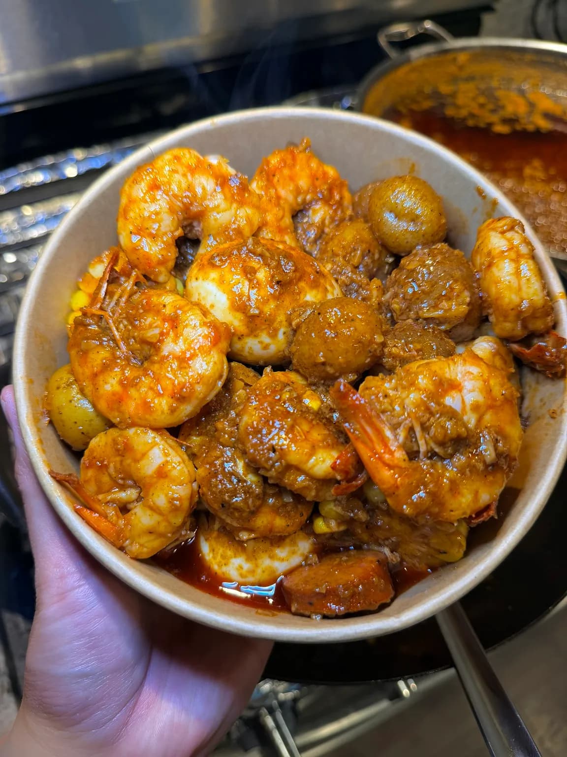 A bowl of shrimps coated in Cajun sauce