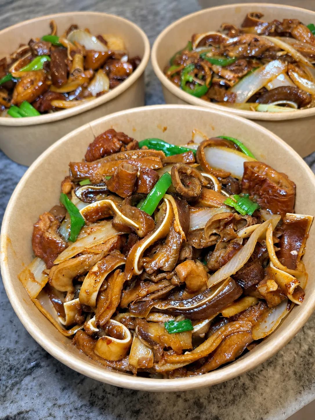 A bowl of pork intestines stir-fried with onion, peppers and green onion